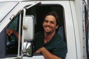 A Truck Driver Looking Out of Window From His Semi Truck