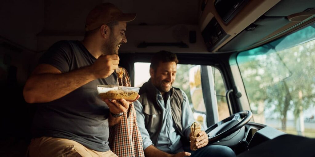 A man trucking with a passenger and eating together